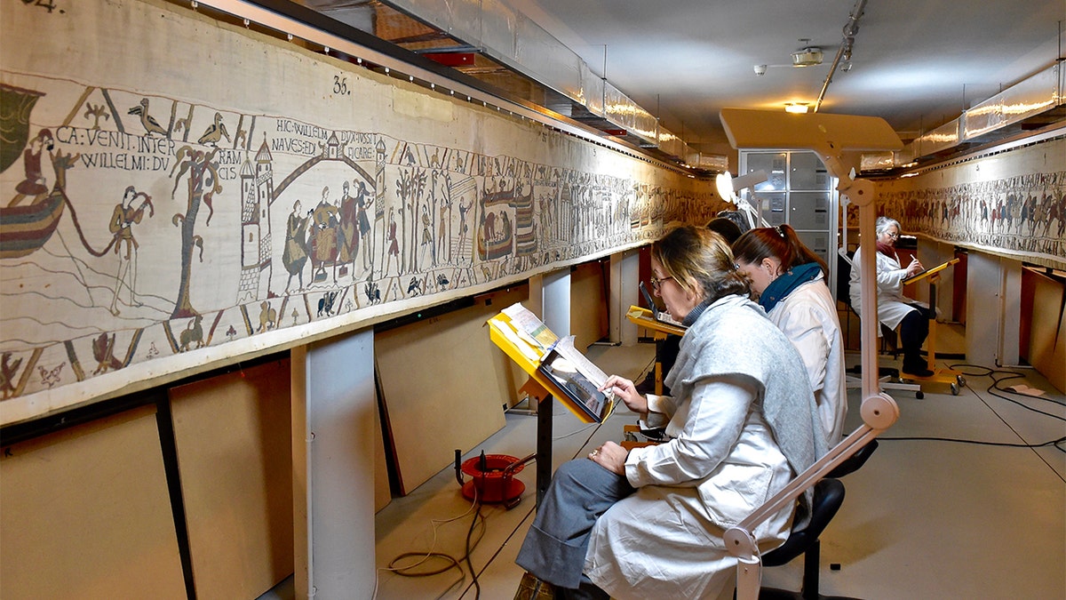 This photo provided by Bayeux townhall shows technicians working at the tapestry in Bayeux, Normandy on Jan. 8 2020. (Ville de Bayeux via AP)