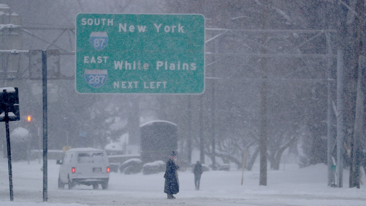 A pedestrian crosses a road in Tarrytown, N.Y. as a nor'easter is blanketing much of New York state on on Monday. Up to two feet of snow is predicted before the storm moves out Tuesday evening. (Reuters)