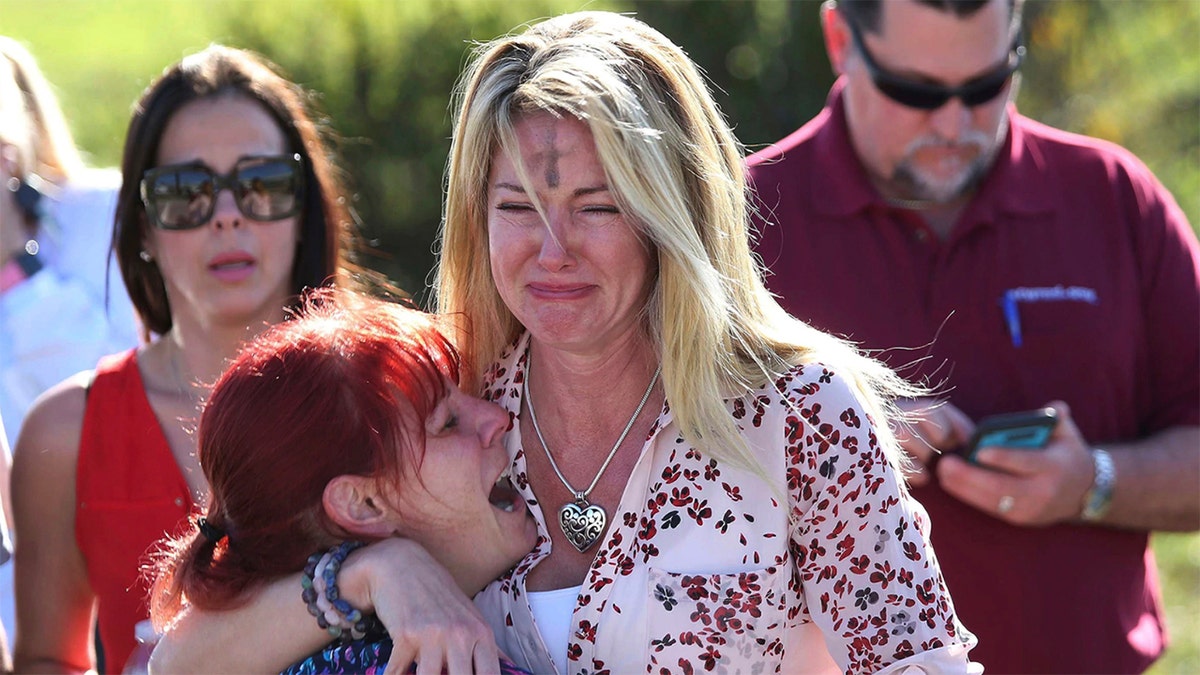 Parents wait for news after a reports of a shooting at Marjory Stoneman Douglas High School in Parkland, Fla., on Wednesday, Feb. 14, 2018.