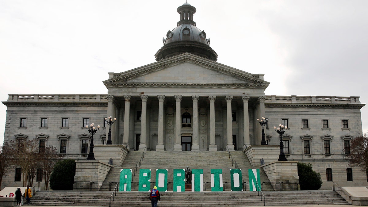 A group who opposes a bill that would ban almost all abortions in South Carolina put up a sign outside the Statehouse on Tuesday, Feb. 2, 2021, in Columbia, S.C. (AP Photo/Jeffrey Collins)