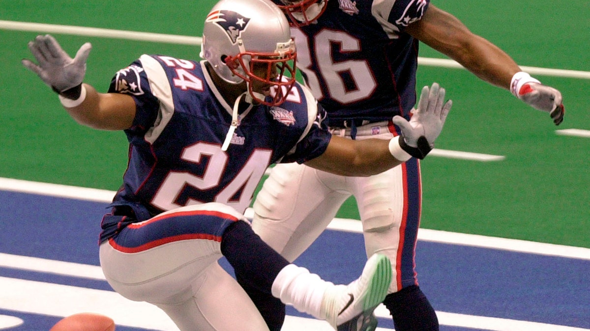 FILE - In this Feb. 3, 2002, file photo, New England Patriots cornerback Ty Law (24) celebrates with teammate Lawyer Milloy after Law's interception of a pass by St. Louis Rams' Kurt Warner for a touchdown during the second quarter of Super Bowl 36 in New Orleans. (AP Photo/Tony Gutierrez, File)