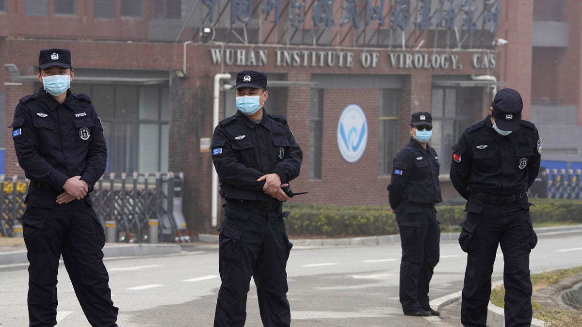 Security personnel gather near the entrance of the Wuhan Institute of Virology during a visit by the World Health Organization team in Wuhan in China's Hubei province on Wednesday, Feb. 3, 2021. 