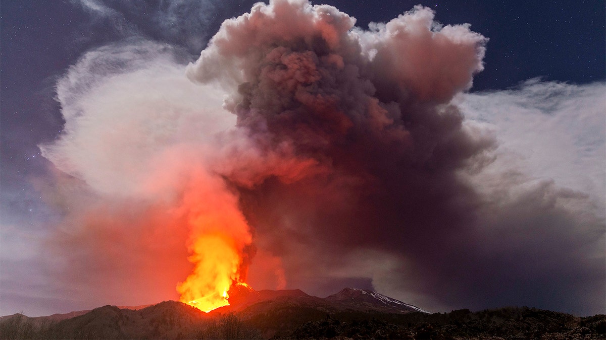 Glowing lava is seen from the north-east side of the Mt Etna volcano engulfed with ashes and smoke near Milo, Sicily, Wednesday night, Feb. 24, 2021.  (AP Photo/Salvatore Allegra)