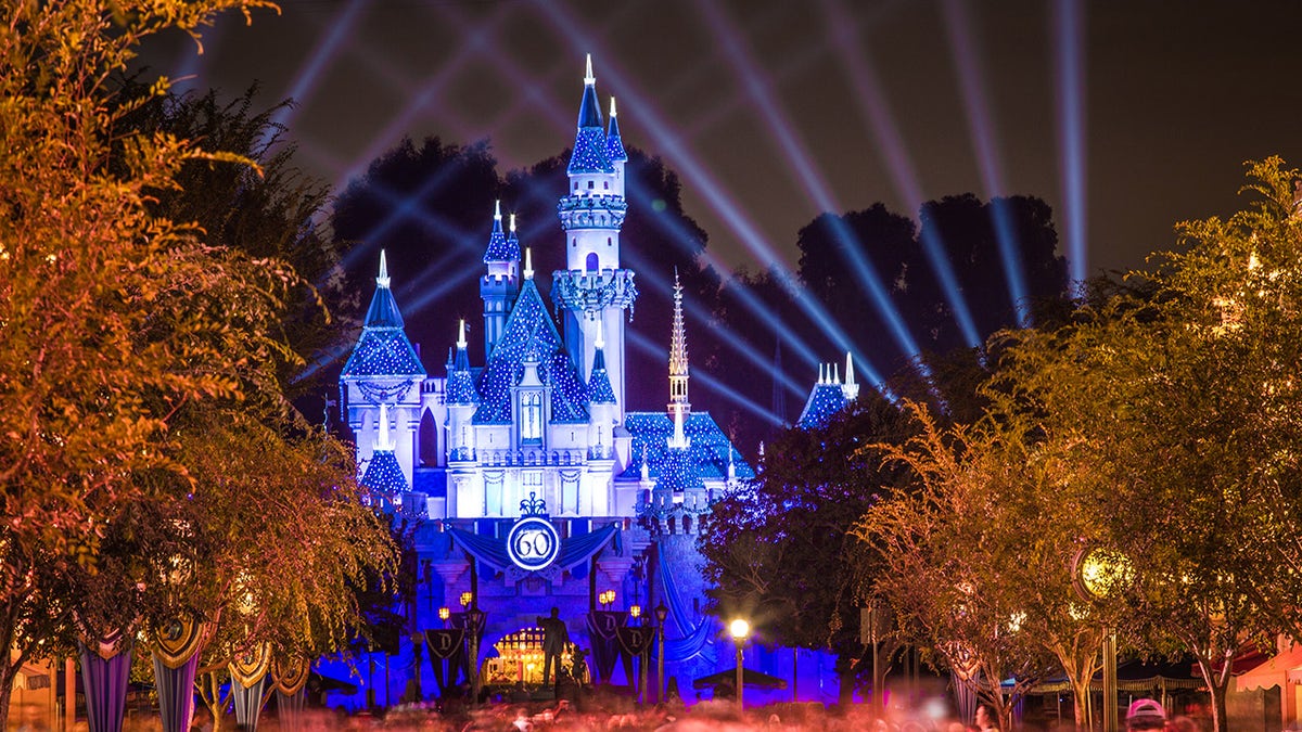Anaheim, CA USA - September 3, 2015: Disneyland 60th celebration castle with people. This year Disneyland celebrates its 60th anniversary of being open. On this day the park is celebrated with fireworks and over 150 thousand people.