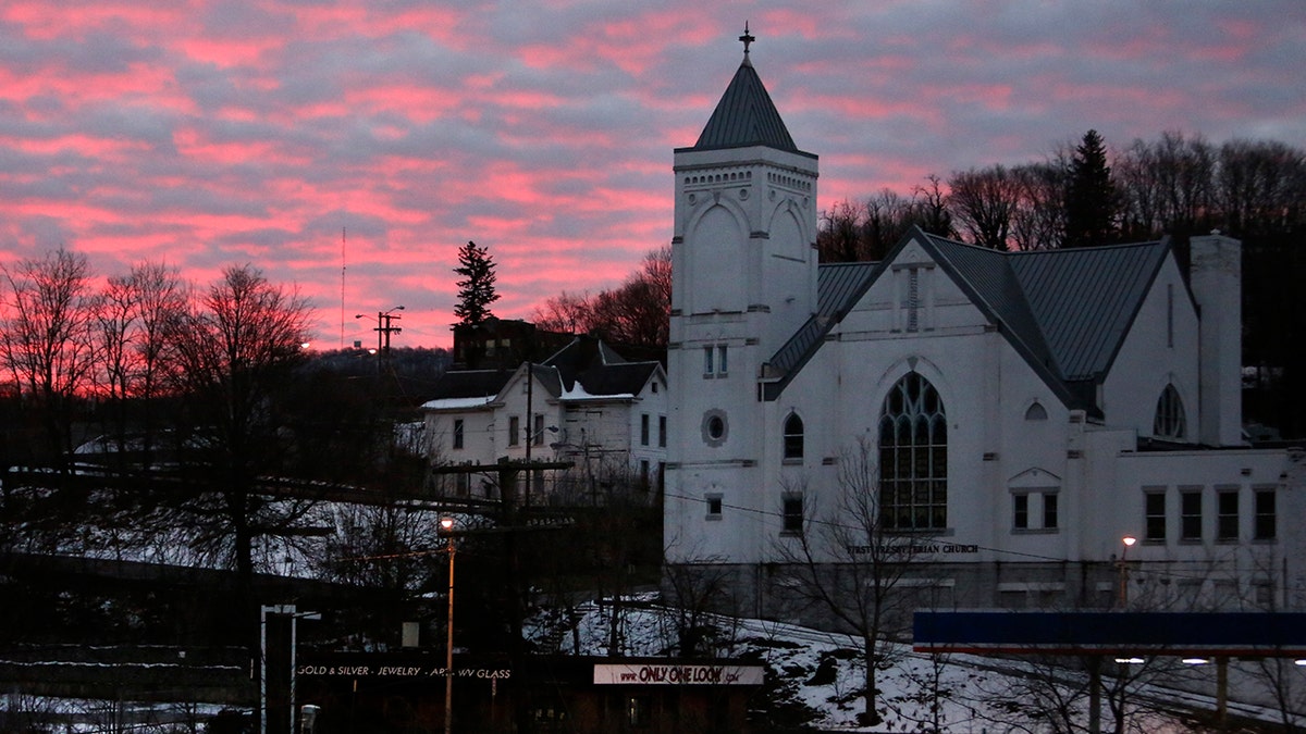 The sky lights up at dawn behind First Presbyterian Church and the rail yard in the historic coal city of Bluefield, W.Va, on Saturday, Jan. 24, 2021. (AP Photo/Jessie Wardarski)