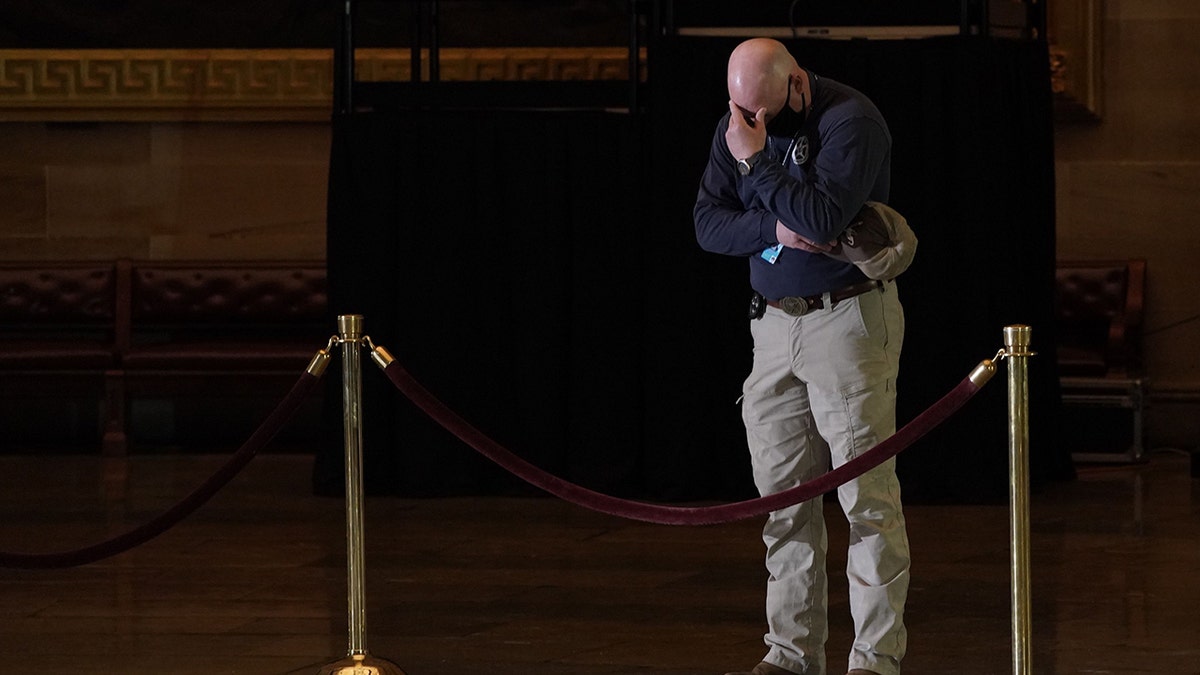 A fellow law enforcement officer gets emotional as he pays his respects to late US Capitol Police officer Brian Sicknick as he lies in honor in the US Capitol Rotunda in Washington, D.C., on February 2, 2021. (Photo by SALWAN GEORGES/POOL/AFP via Getty Images)