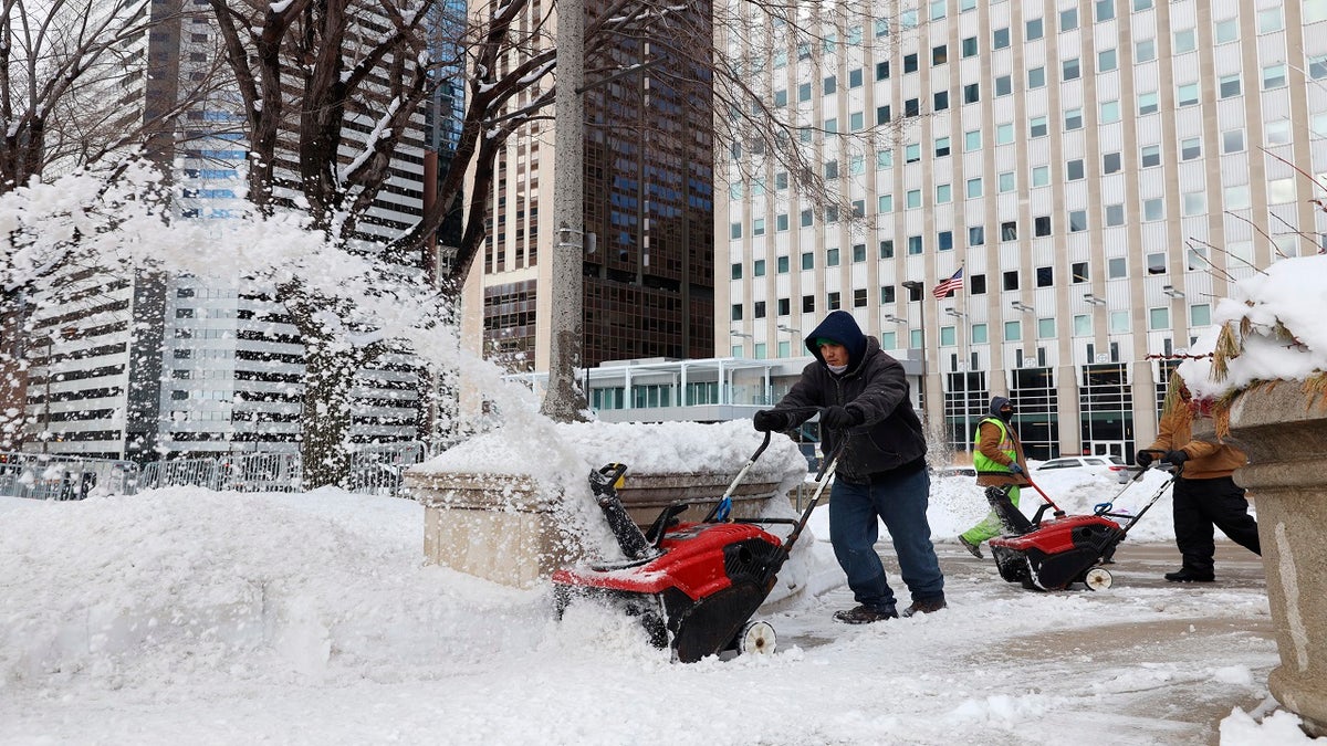 A worker uses a snowplow to shovel snow at Chicago's Millennium Park on Monday after a weekend-long winter storm dumped about a foot of snow in the greater Chicago area. (AP)