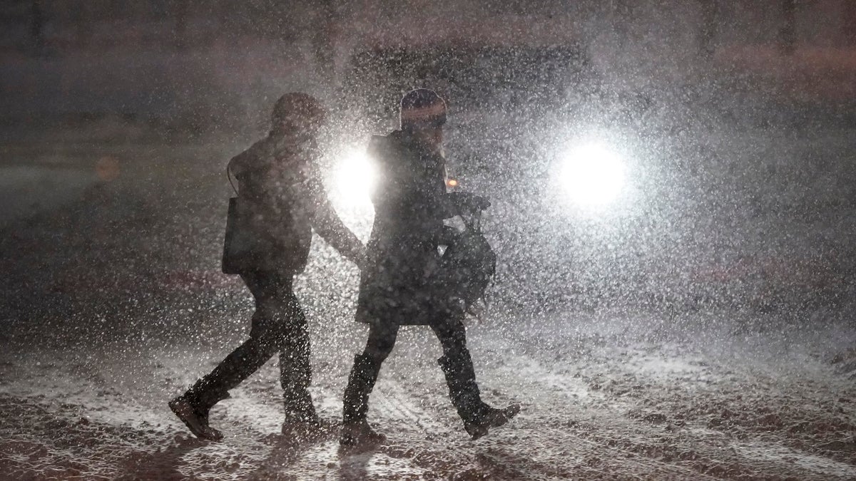 Pedestrians cross a street in Denver as heavy snowfall swept over the region Wednesday night. (AP)