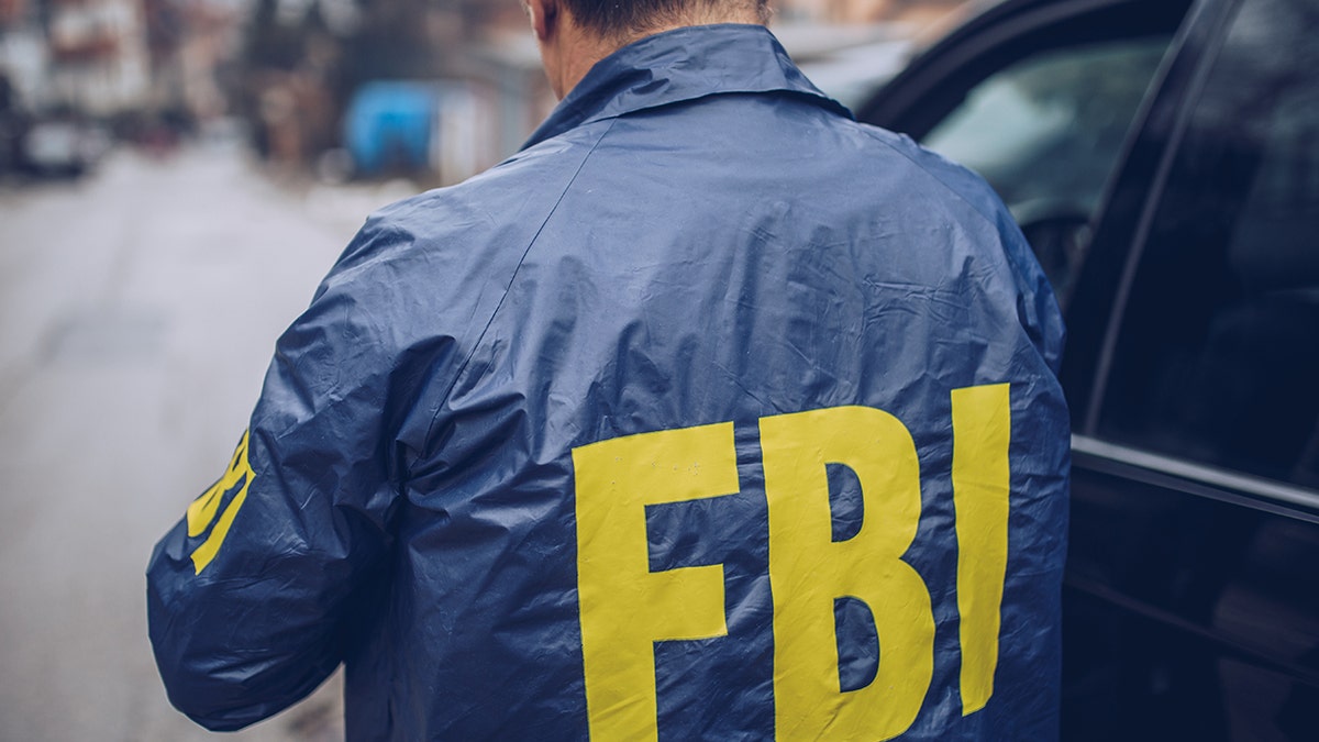 شوهد عميل FBI الذكور في الصور التي ترتدي سترة مكتب التحقيقات الفيدرالي