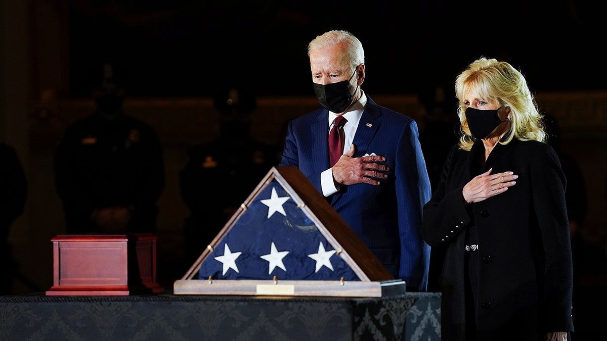 President Joe Biden and first lady Jill Biden pay their respects to the late U.S. Capitol Police officer Brian Sicknick as an urn with his cremated remains lies in honor on a black-draped table at the center of Capitol Rotunda, Tuesday, Feb. 2, 2021, in Washington. (Erin Schaff/The New York Times via AP, Pool)