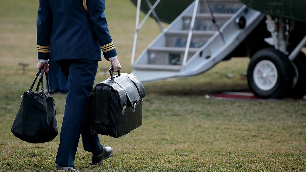 FILE - A military aide carries the alleged 'football,' a case with the launch codes for nuclear weapons, toward Marine One as former President Donald Trump prepares to take off. (Photo by Drew Angerer/Getty Images)