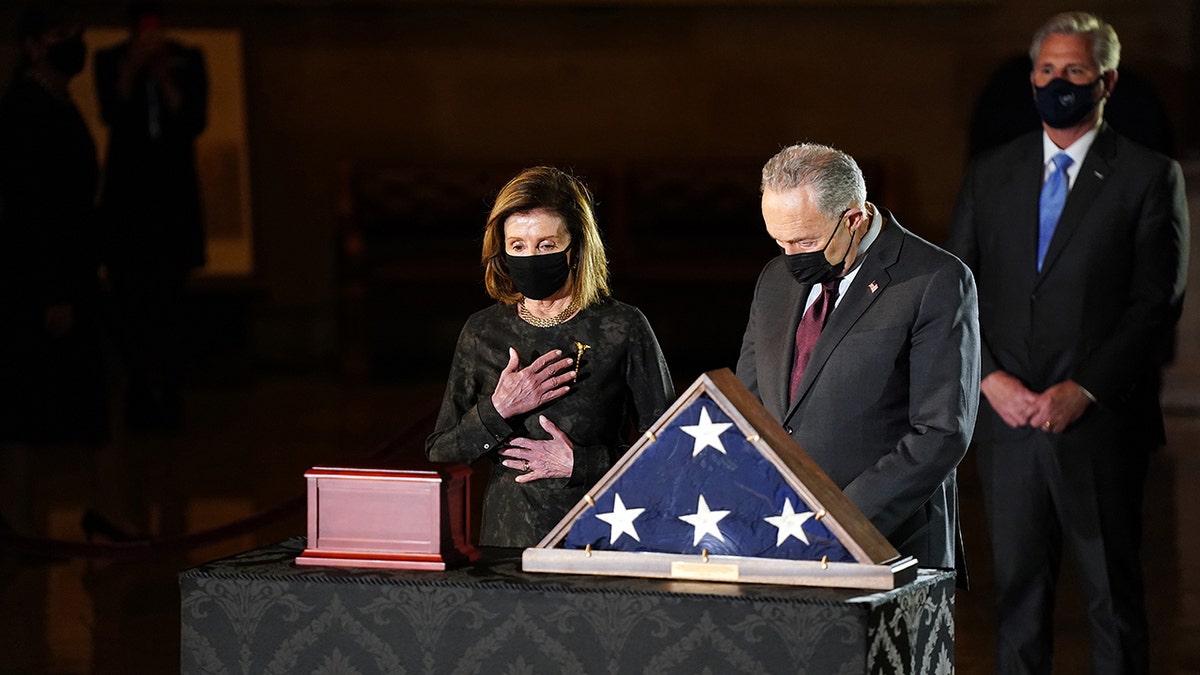 U.S. House Speaker Nancy Pelosi, a Democrat from California, left, and Senate Majority Leader Chuck Schumer, a Democrat from New York, pay their respects in front of the remains of U.S. Capitol Police Officer Brian Sicknick in the Rotunda of the U.S. Capitol in Washington, D.C., on Tuesday, Feb. 2, 2021. Photographer: Erin Schaff/The New York Times/Bloomberg via Getty Images