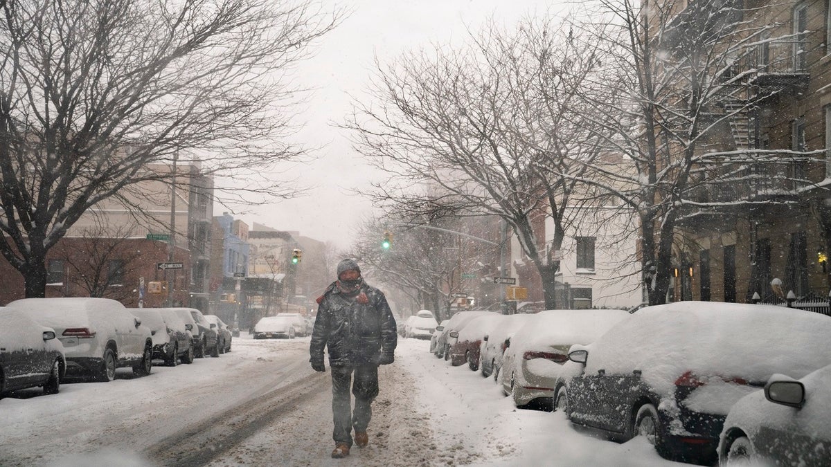 A pedestrian walks down a snow covered street in the Brooklyn borough of New York City on Monday. (AP)