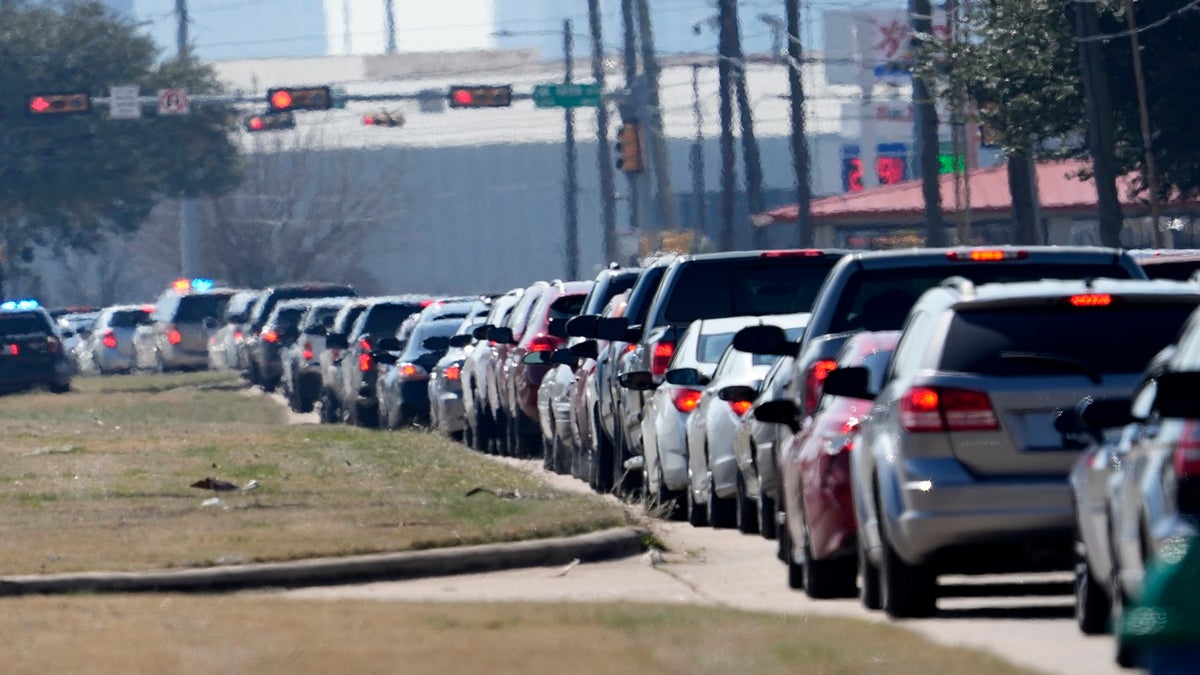Car are lined up outside at a City of Houston water distribution site on Friday. The drive-thru stadium location was setup to provide bottled water to individuals who need water while the city remains on a boil water notice or because they lack water at home due to frozen or broken pipes. (AP)