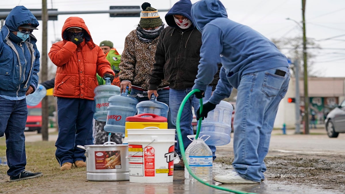 Jose Blanco, right, fills a cooler with water from a park spigot as others wait in line Thursday in Houston. Houston and several surrounding cities are under a boil water notice as many residents are still without running water in their homes. (AP)