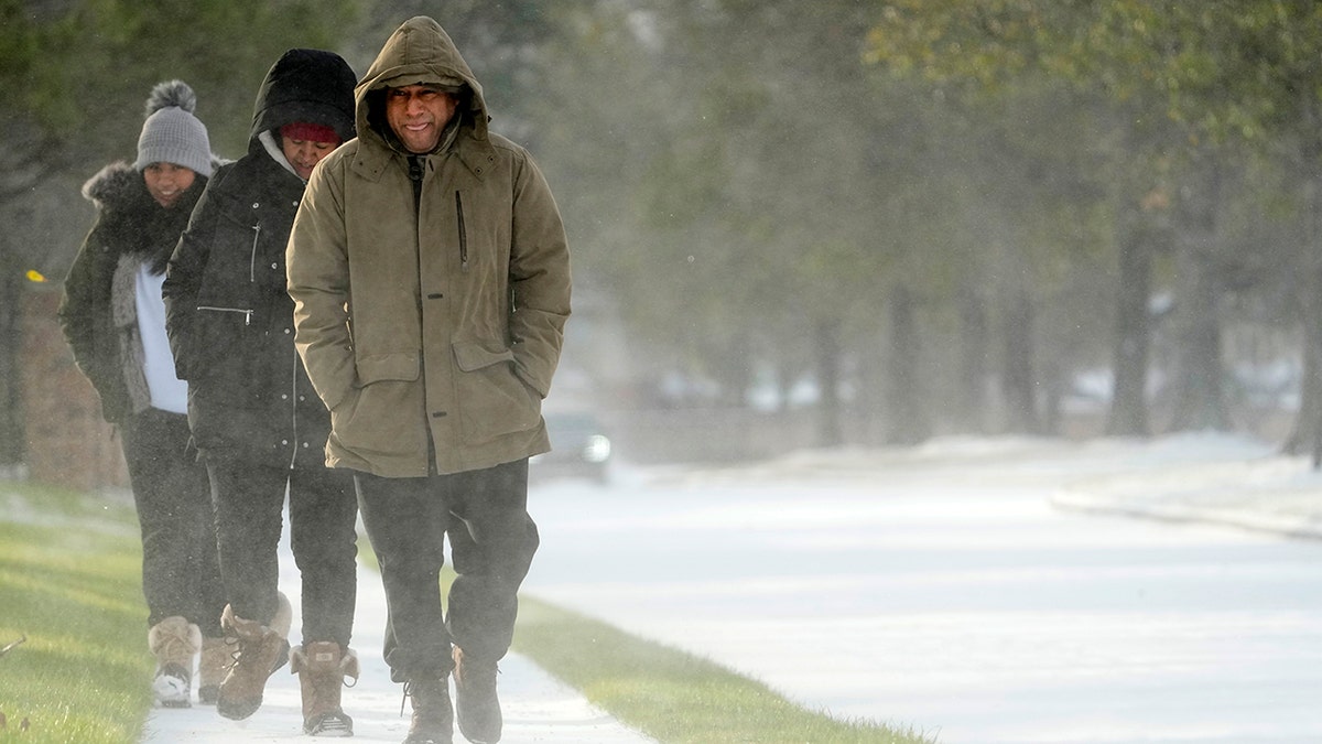 Erasmo Vazquez, right, walks along a snow covered sidewalk with his wife, Maria, center, and daughter Day, left, Monday, Feb. 15, 2021, in Houston. 