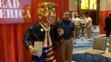 Gold-colored Trump statue at CPAC draws crowd