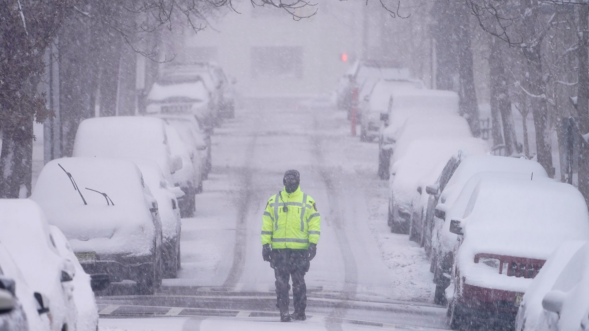 A traffic officer patrols a lightly trafficked street in Weehawken, N.J., Monday, Feb. 1, 2021. Snowfall is picking up in the Northeast as the region braced for a whopper of a storm that could dump well over a foot of snow in many areas, create blizzard-like conditions and cause travel problems for the next few days. (AP Photo/Seth Wenig)