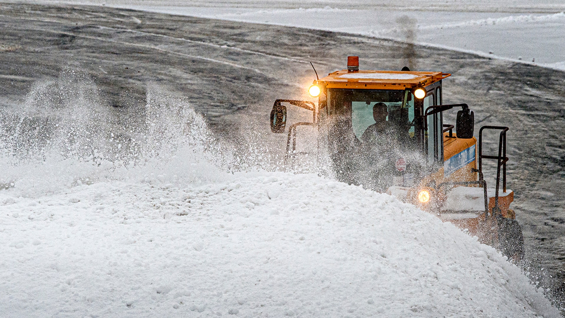 Snow is piled by a loader in the Tri-City Plaza shopping center in Vernon, Conn., Monday, Feb. 1, 2021. The National Weather Service has issued a Winter Storm Warning through Tuesday with a forecast of 7-15 inches in the region.
