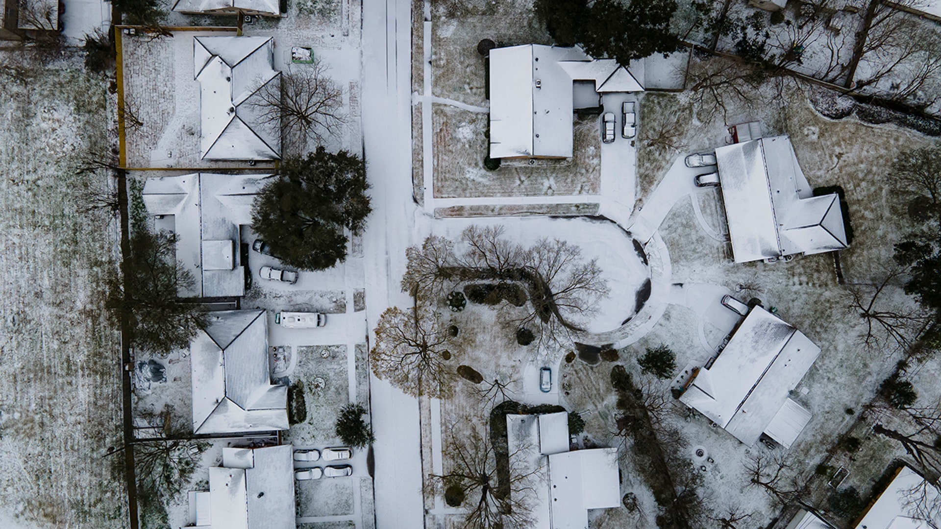 Homes in the Westbury neighborhood are covered in snow in Houston, Monday, Feb. 15, 2021, in Houston. A winter storm making its way from the southern Plains to the Northeast is affecting air travel.