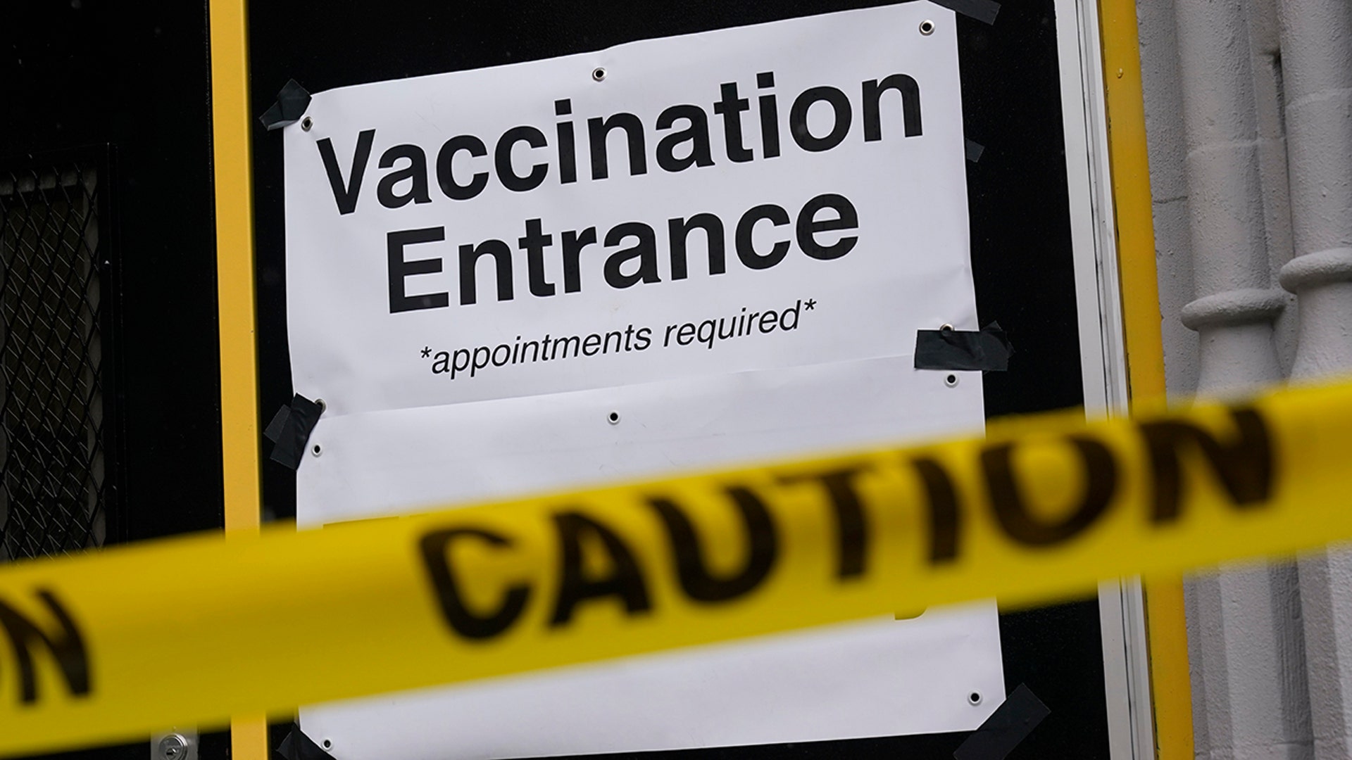 Caution tape lets people know that a COVID-19 vaccination site is closed in New York, Tuesday, Feb. 2, 2021. Coronavirus vaccination sites across the northeastern U.S. are getting back up and running after a two-day snowstorm that also shut down public transport, closed schools and canceled flights. Some vaccination sites in New York City remained closed, but others, including those run by the public hospital system, were open Tuesday.