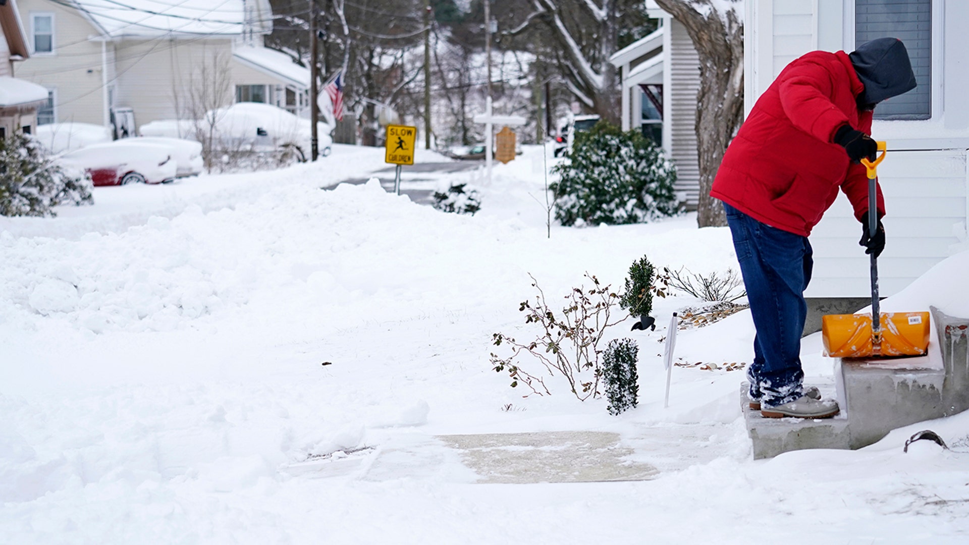 A man finishes shoveling his walkway after a winter storm dumped about a foot of snow, Tuesday, Feb. 2, 2021, in Derry, N.H.