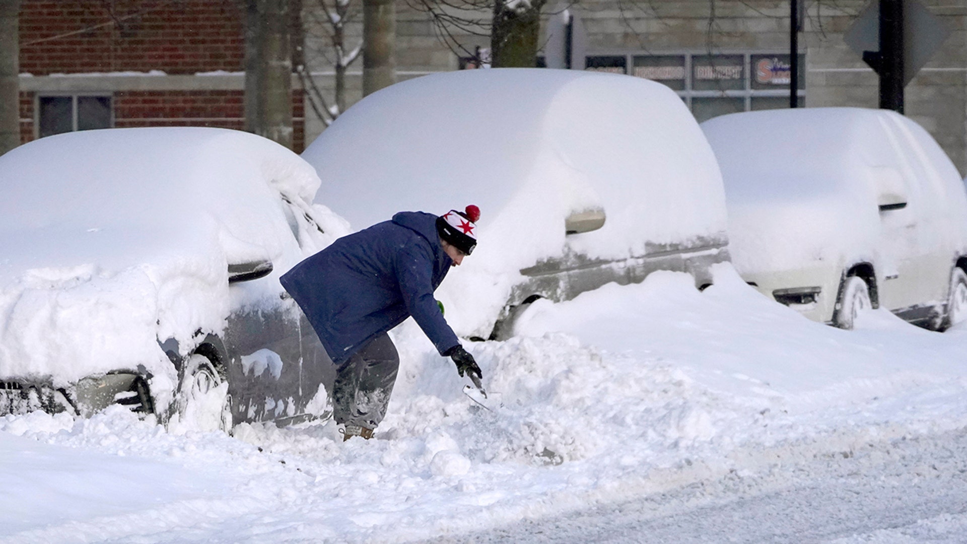 A motorist digs a path to his car Tuesday, Feb. 16, 2021, after an overnight snow storm dumped up to 18.5 inches in the Chicago area.