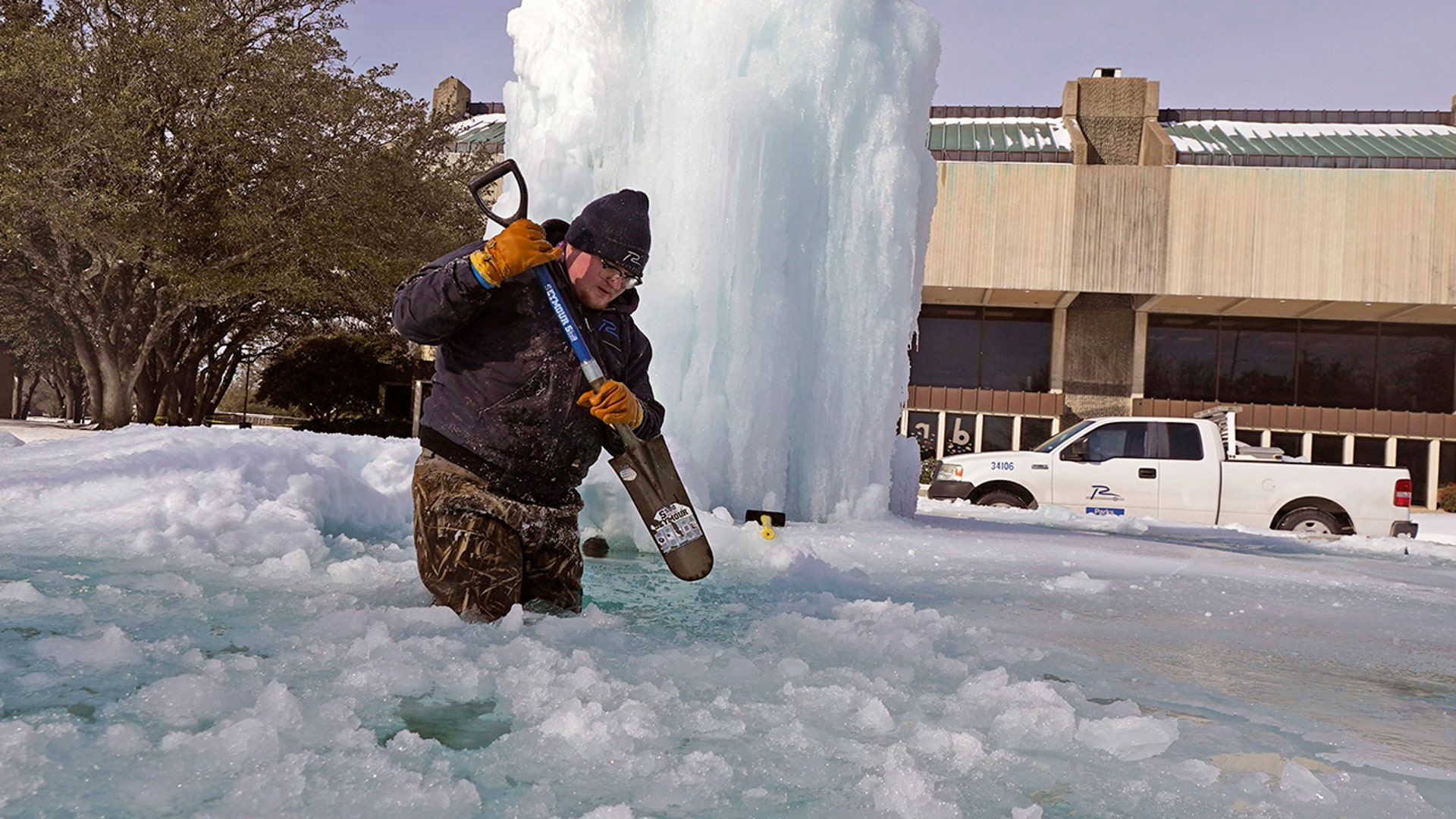 City of Richardson worker Kaleb Love breaks ice on a frozen fountain Tuesday, Feb. 16, 2021, in Richardson, Texas. Temperatures dropped into the single digits as snow shut down air travel and grocery stores. (AP Photo/LM Otero)