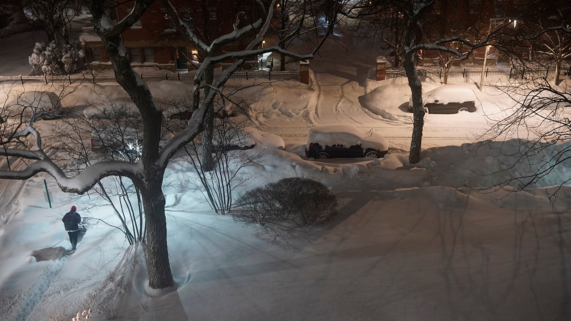 A maintenance worker plows fresh fallen snow Tuesday, Feb. 16, 2021, in the Bronzville neighborhood of Chicago. A winter storm has blanketed the Chicago area overnight with up to 18.5 inches of snow.