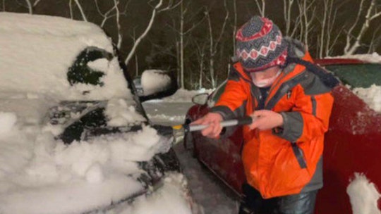 Family friends clear snow from Rhode Island hospital staff's cars in the midst of winter storm