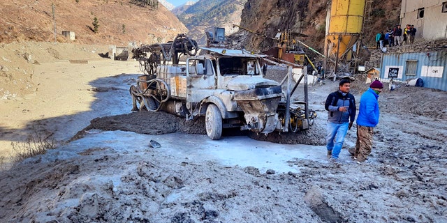 People inspect the site near the damaged Dhauliganga hydropower project at Reni village in Chamoli district after a portion of Nanda Devi glacier broke off in Tapovan area of the northern state of Uttarakhand, Sunday, Feb.7, 2021. (AP Photo)