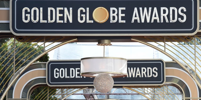 FILE - Event signage appears above the red carpet at the 77th annual Golden Globe Awards, on Jan. 5, 2020, in Beverly Hills, Calif. The 78th annual Golden Globes will be held on Sunday, Feb. 18, 2021. (Photo by Jordan Strauss/Invision/AP, File)