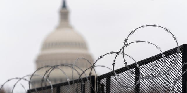 The U.S. Capitol is seen behind the razor fence around the U.S. Capitol, Thursday, Feb. 18, 2021.
