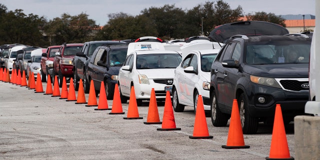 Hundreds of cars come through NRG Park to get food supplies during the Neighborhood Super Site food distribution event organized by the Houston Food Bank and HISD, Sunday, Feb. 21, 2021, in Houston. (Marie D. De Jesús/Houston Chronicle via AP)