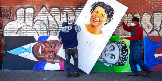 Artists set up a painting of Stacey Abrams in the King Historic District on Monday, Jan. 18, 2021, in honor of Martin Luther King Jr. Day, in Atlanta.