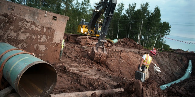 In a file photo dated Aug. 21, 2017, workers are ensuring that any section of Enbridge Replacement Line 3 that will be connected passes through muster in Superior, Wisc.  (Richard Tsong-Taatarii / Star Tribune via AP)