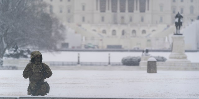 A National Guard soldier stands a post as snow falls in front of the U.S Capitol, Sunday, Jan. 31, 2021, in Washington. (AP Photo/Alex Brandon)
