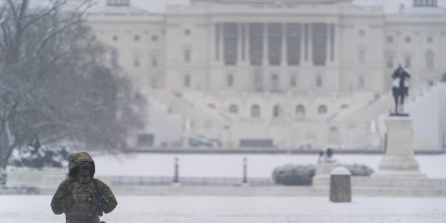 A National Guard soldier stands a post as snow falls in front of the U.S Capitol, Sunday, Jan. 31, 2021, in Washington. (AP Photo/Alex Brandon)