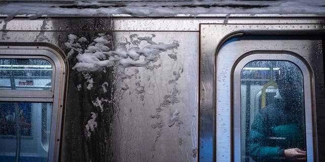 A man waits to alight from a New York City subway car covered with ice during a snowstorm, Monday, Feb. 1, 2021, in New York. (AP Photo/Wong Maye-E)