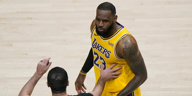 Los Angeles Lakers forward LeBron James (23) is restrained by an official as he reacts to a fan in the second half of an NBA basketball game against the Atlanta Hawks, Monday, Feb. 1, 2021, in Atlanta. (AP Photo/John Bazemore)