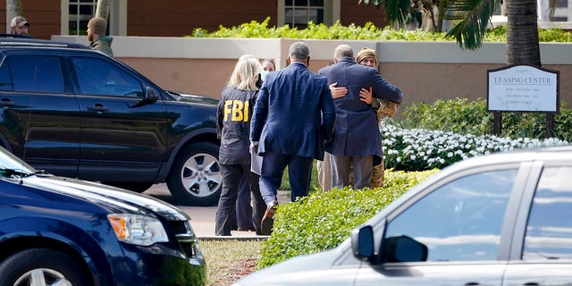 Law enforcement officers work where a shooting occurred wounded several FBI personnel while serving an arrest warrant, Tuesday, Feb. 2, 2021, in Sunrise, Fla. Police in South Florida have swarmed a neighborhood following a Tuesday morning shooting involving FBI agents. (AP Photo/Marta Lavandier)