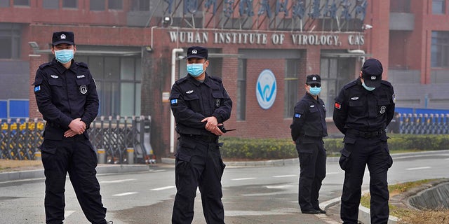 2021 年 2 月 3 日水曜日、中国湖北省の武漢にある世界保健機関のチームによる訪問中に、武漢ウイルス学研究所の入り口付近に集まる治安要員。
