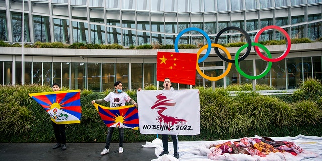 Protesters hold Tibetan flags during a protest against Beijing 2022 Winter Olympics by activists of the Tibetan Youth Association in Europe, in front of the International Olympic Committee, IOC, headquarters in Lausanne, Switzerland, Wednesday, Feb. 3, 2021. A coalition of 180 rights groups is calling for a boycott of next year's Beijing Winter Olympics tied to reported human rights abuses in China. The games are to open on February 4, 2022. The coalition is made up of groups representing Tibetans, Uighurs, Inner Mongolians and others. The group has issued an open letter to governments calling for a boycott of the Olympics "to ensure they are not used to embolden the Chinese government’s appalling rights abuses and crackdowns on dissent."  (Jean-Christophe Bott/Keystone via AP)