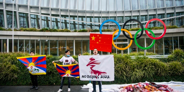 Protesters hold Tibetan flags during a protest against Beijing 2022 Winter Olympics by activists of the Tibetan Youth Association in Europe, in front of the International Olympic Committee, IOC, headquarters in Lausanne, Switzerland, Wednesday, Feb. 3, 2021. A coalition of 180 rights groups is calling for a boycott of next year's Beijing Winter Olympics tied to reported human rights abuses in China. The games are to open on February 4, 2022. The coalition is made up of groups representing Tibetans, Uighurs, Inner Mongolians and others. The group has issued an open letter to governments calling for a boycott of the Olympics "to ensure they are not used to embolden the Chinese government's appalling rights abuses and crackdowns on dissent." (Jean-Christophe Bott/Keystone via AP)