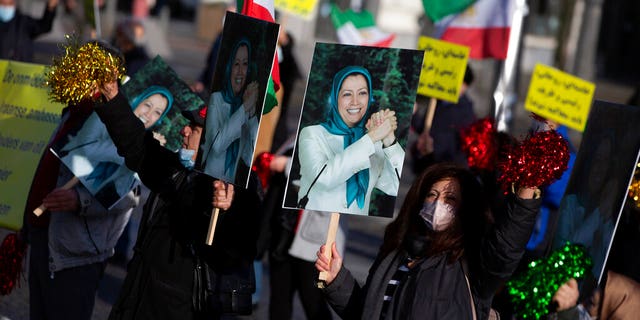 People demonstrate while holding photos of Maryam Rajavi, leader of the National Council of Resistance of Iran, during the trial of four persons, including an Iranian diplomate and Belgian-Iranian couple at the courthouse in Antwerp, Belgium, Thursday, Feb. 4, 2021. (AP Photo/Virginia Mayo)