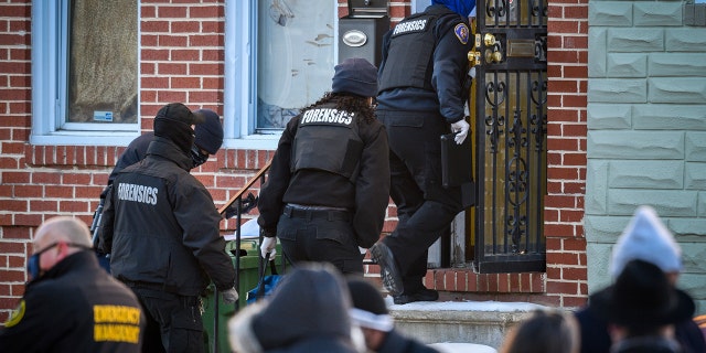 A Baltimore Police forensics team enters the house in West Baltimore where a U.S. Marshall was shot while serving an arrest warrant on Thursday, Feb.. 4, 2021. (Jerry Jackson/The Baltimore Sun via AP)