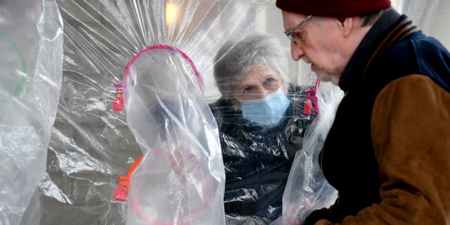 Lynda Hartman, 75, visits her 77-year-old husband, Len Hartman, in a "hug tent" set up outside the Juniper Village assisted living center in Louisville, Colorado, on Wednesday. (AP Photo/Thomas Peipert)