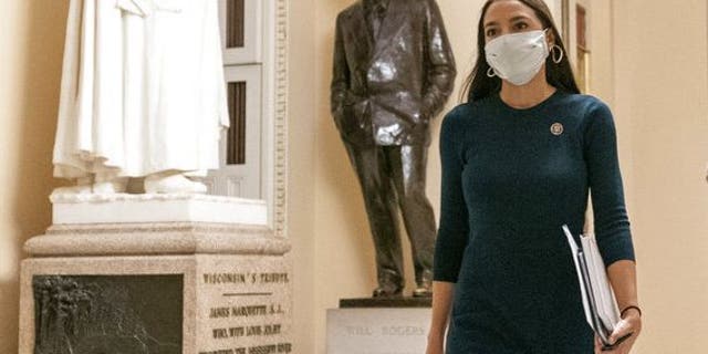 Rep. Alexandria Ocasio-Cortez, D-N.Y., walks towards the House floor during a vote to remove Rep. Marjorie Taylor Greene, R-Ga., from committee assignments over her extremist views, on Capitol Hill in Washington, Thursday, Feb. 4, 2021. (AP Photo/Andrew Harnik)