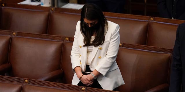 FILE - In this early Thursday, Jan 7, 2021 file photo, Rep. Alexandria Ocasio-Cortez, D-N.Y., bows her head during a closing prayer of a joint session of the House and Senate to confirm Electoral College votes at the Capitol in Washington. (AP Photo/Andrew Harnik)