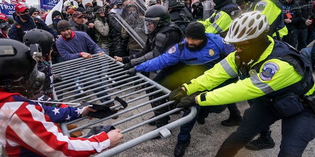 Pro-Trump supporters try to break through a police barrier at the Capitol in Washington on Jan. 6, 2021. (AP Photo/John Minchillo, File)